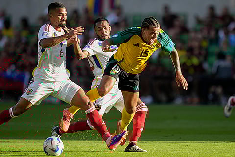 Joel Latibeaudiere is tripped up by Venezuela's Yangel Herrera